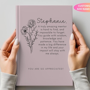 May include: A pink journal with a floral design and the text "Stephanie. A truly amazing mentor is hard to find, and impossible to forget. You guide with wisdom, knowledge and patience. You have made a big difference in my life and your impact will stay with me always. YOU ARE SO APPRECIATED!"