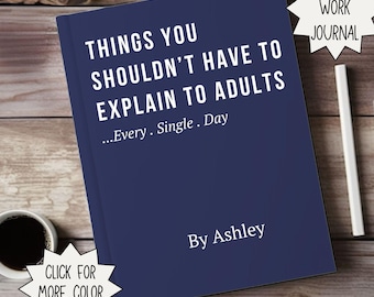 May include: A navy blue journal with the text "THINGS YOU SHOULDN'T HAVE TO EXPLAIN TO ADULTS" in white. The journal also includes the text "...Every. Single. Day" and "By Ashley". A white pen and a cup of coffee are next to the journal.
