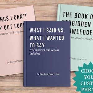 May include: Three books with humorous titles are displayed on a wooden surface. The books are titled "Things I Can't Say Out Loud", "What I Said Vs. What I Wanted to Say", and "The Book of Forbidden Knowledge". A teal starburst graphic says "Choose Your Custom Phrase".