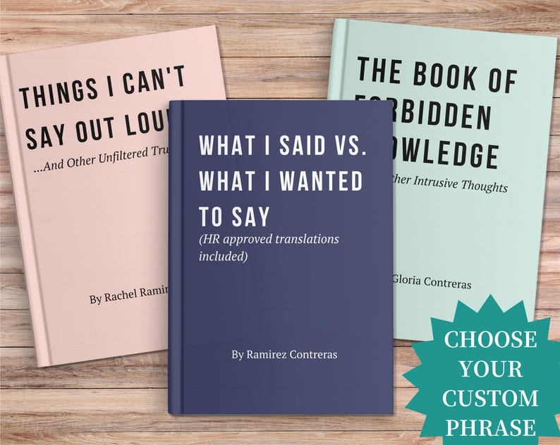 May include: Three books with humorous titles are displayed on a wooden surface. The books are titled "Things I Can't Say Out Loud", "What I Said Vs. What I Wanted to Say", and "The Book of Forbidden Knowledge". A teal starburst graphic says "Choose Your Custom Phrase".