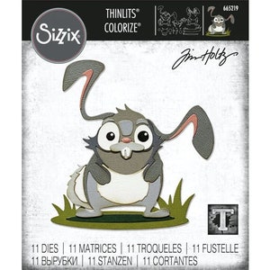 May include: A die-cut design featuring a cartoon bunny with large ears, a gray and white color scheme, and a friendly expression. The design is part of a set of 11 dies for crafting and scrapbooking.