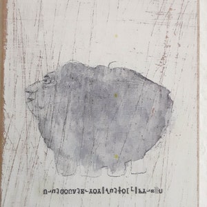 May include: A gray abstract painting with a white background. The painting features a gray, blob-like shape with a face and a few yellow dots. The text "U-LA-201-XOX-3-000000-U" is written at the bottom of the painting.