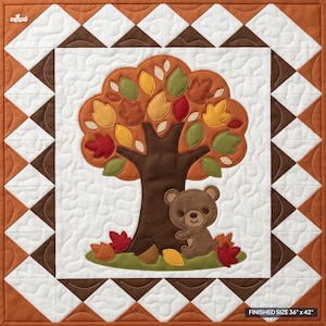 May include: A square quilt featuring a central applique of a brown bear sitting under an autumn tree with red, yellow, and green leaves. The border consists of brown and white triangles. The text FINISHED SIZE 36" x 42" is printed in the corner.