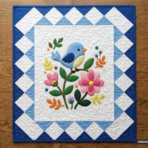 Può includere: Una trapunta rettangolare con un pannello centrale bianco raffigurante un uccellino blu appollaiato su uno stelo circondato da fiori rosa e foglie verdi. Il bordo è composto da rombi blu e bianchi. La dimensione finita è 91 cm per 107 cm.
