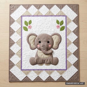 May include: A rectangular quilt featuring a central applique of a gray elephant with pink cheeks on a white stippled background. The border consists of a diamond pattern in white and tan. The quilt includes text stating a finished size of 36" x 42".