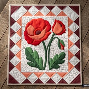 Puede incluir: Un tapiz rectangular de tela con una gran amapola roja con hojas verdes y un capullo sobre un fondo blanco con patrones de acolchado en espiral. El borde consta de triángulos blancos, naranjas y rojo oscuro. Tamaño 91 cm x 107 cm.