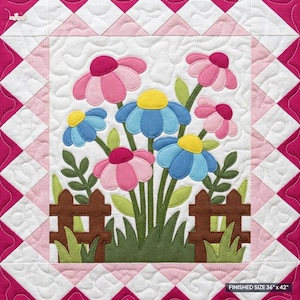 Può includere: Un arazzo trapuntato con un motivo floreale centrale di fiori rosa e blu, steli e foglie verdi dietro una staccionata marrone. Il bordo è composto da triangoli rosa e bianchi. La dimensione finita è di 91,44 cm per 106,68 cm.