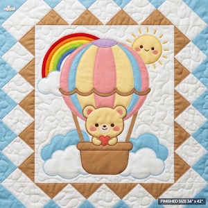 Puede incluir: Una manta acolchada con un aplique central de un oso marrón claro sosteniendo un corazón rojo dentro de un globo aerostático en tonos pastel. Incluye un arcoíris, un sol sonriente y nubes blancas sobre fondo blanco con un borde azul y marrón.