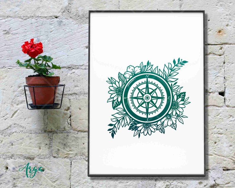 Peut inclure: Une boussole vert turquoise entour&eacute;e de motifs floraux, y compris des tournesols et d'autres fleurs. La boussole porte les lettres N, S, E et W.
