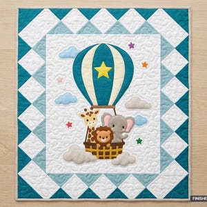 Op de afbeelding: Een rechthoekige quilt met een centrale heteluchtballon met een gele ster, waarin een giraf, leeuw en olifant zitten. Het ontwerp bevat wolken en sterren op een witte achtergrond met een blauwgroene en witte ruitvormige rand. Afmeting 91 cm x 107 cm.