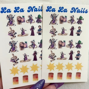 May include: Two sheets of nail art stickers featuring characters from the Disney film Tangled. The stickers include Rapunzel, Flynn Rider, Pascal the chameleon, and Mother Gothel. The stickers also include images of the sun and lanterns.
