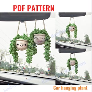 May include: Two crocheted hanging plants with smiling faces, in a car with a rearview mirror. The plants are green and white and have long strands of yarn hanging down. The text "PDF PATTERN" is at the top of the image. The text "Car hanging plant" is at the bottom of the image.