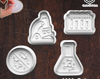 Könnte beinhalten: Vier weiße Ausstecher aus Kunststoff in wissenschaftlichen Formen: ein Mikroskop, Reagenzgläser, ein Kolben mit einer Molekularstruktur und eine Petrischale mit einem durchgestrichenen Mikrobensymbol. Der Text "0390_Full" steht unten.