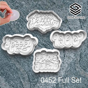 May include: Four white Halloween-themed cookie cutters with the words "Happy Halloween", "Spooky", "Boo", and "Trick or Treat". The text "0452 Full Set" is at the bottom. The Ozzie 3D Prints logo is in the upper right corner. The cutters are 3D-printed.