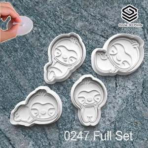 May include: Four white plastic sloth-shaped cookie cutters in various poses. The cutters include sloths lying down and standing. The text "0247 Full Set" is printed at the bottom. The Ozzie 3D Prints logo is in the upper right corner.