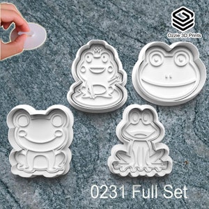 May include: Four white plastic frog-shaped cookie cutters are displayed. One frog wears a crown, another has glasses, and the others have smiling faces. The text "0231 Full Set" is printed at the bottom. The logo "Ozzie 3D Prints" is in the upper right corner.