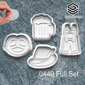May include: Four white plastic cookie cutters featuring a pretzel, beer mug, lederhosen, and a hat with a feather. The text "0440 Full Set" is printed below the cutters. The logo "Ozzie 3D Prints" is in the upper right corner.