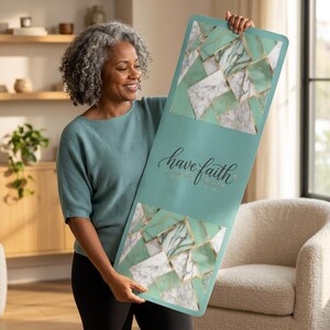 Può includere: Un tappetino da yoga rettangolare di colore verde acqua tenue con una sezione centrale che riporta il testo have faith in caratteri scuri. Le parti superiore e inferiore presentano un motivo geometrico a mosaico in marmo bianco.