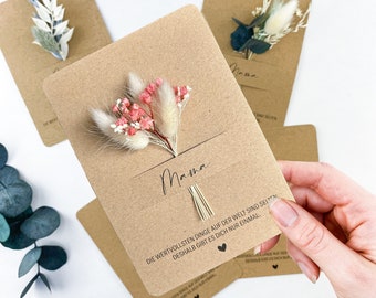 Könnte beinhalten: Eine braune Karte mit einem getrockneten Blumenstrauß, der daran befestigt ist. Die Karte trägt das Wort "Mama" und den Text "Die wertvollsten Dinge der Welt sind selten, deshalb bist du einzigartig."