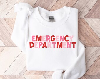 May include: White sweatshirt with the words "EMERGENCY DEPARTMENT" in pink and red letters.