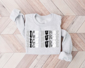 May include: Gray sweatshirt with the words "ICU Nurse" repeated three times in a retro, wavy font. The letters are in black, white, and gray.