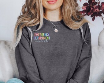 May include: A dark gray sweatshirt with the text "EMERGENCY DEPARTMENT nurse" in rainbow colors on the front.