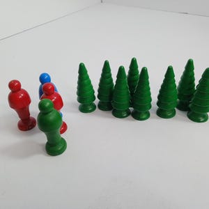 以下が含まれることがあります： 緑のプラスチック製の玩具の木と赤と青のプラスチック製の玩具の人々。木は一列に並べられ、人々はグループで立っています。