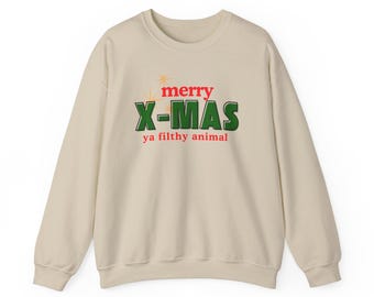 May include: A cream-coloured sweatshirt featuring the text "merry X-MAS ya filthy animal" in red and green. The design includes a starburst graphic above the word "merry". A festive holiday-themed garment.