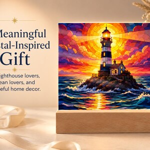 K&ouml;nnte beinhalten: Eine quadratische Acrylplatte mit einer farbenfrohen Illustration im Buntglas-Stil eines Leuchtturms auf einer felsigen Insel bei Sonnenuntergang, auf einem rechteckigen Holzsockel. Der Text lautet: A Meaningful Coastal-Inspired Gift. For lighthouse lovers, ocean lovers, and peaceful home decor.