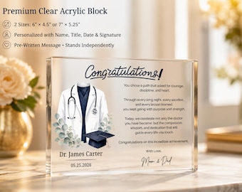 May include: A clear acrylic block featuring the word "Congratulations!" and a doctor's coat illustration. It includes the name "Dr. James Carter" and the date "05.25.2026". Available in sizes 15.24cm x 11.43cm or 17.78cm x 13.34cm.