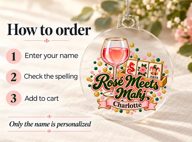 Op de afbeelding: Een doorzichtige ronde acryl hanger met een afbeelding van een wijnglas gevuld met roze vloeistof, drie mahjongtegels en de tekst Ros&eacute; Meets Mahj. Een roze banner eronder toont de naam Charlotte, omringd door gouden en groene stippen.