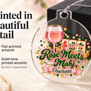 Op de afbeelding: Een ronde, transparante acryl hanger met een opdruk van een wijnglas gevuld met ros&eacute;, mahjongtegels en de tekst "Ros&eacute; Meets Mahj" boven een roze banner met de naam "Charlotte". Het ontwerp bevat goudkleurige accenten.