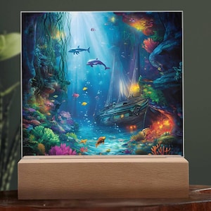 May include: A decorative light-up panel featuring an underwater scene with a sunken ship, dolphins, and colorful coral. The artwork is set on a wooden base, creating a vibrant and illuminated display.