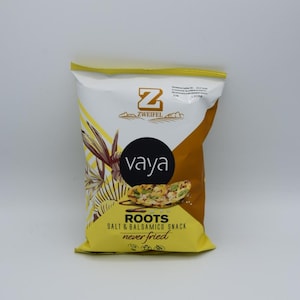 Könnte beinhalten: Eine gelbe Tüte Zweifel Vaya Roots Salz & Balsamico Snack. Die Tüte zeigt ein grünes Pflanzenmotiv und den Text "never fried".