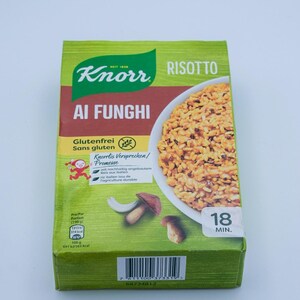 Könnte beinhalten: Eine grüne und braune Schachtel Knorr Risotto Ai Funghi. Die Verpackung zeigt das Knorr-Logo, die Worte "Risotto Ai Funghi" und ein Bild des Risottos. Auf der Schachtel steht auch, dass es glutenfrei ist und in 18 Minuten fertig ist.