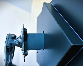 May include: A black monitor arm with a square mounting plate. The arm is attached to the plate with screws. The arm is designed to hold a monitor.