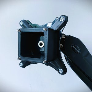 May include: Black monitor arm with a square mounting plate and the word "INVISION" printed on the arm.