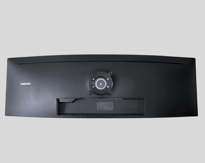 Pu&ograve; includere: Il retro di un monitor Samsung curvo nero con un attacco per supporto circolare.