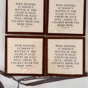 May include: Four framed square art prints with a quote about wine and friendship. The quote reads, "With friends, it doesn't matter if the glass is half empty or half full. There is clearly room for more wine."