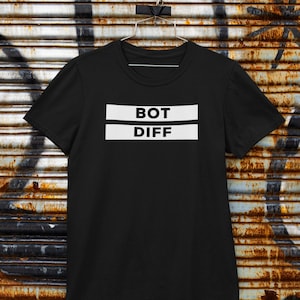 Puede incluir: Camiseta negra con texto blanco que dice "BOT DIFF" sobre un fondo de metal oxidado.