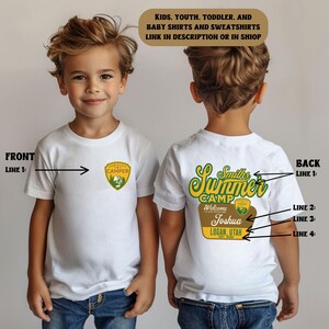 Puede incluir: Camiseta blanca con un parche verde y amarillo "Made with Adventure Camper" en la parte delantera. La parte trasera presenta un dise&ntilde;o "Smith's Summer Camp" con el nombre "Joshua" y "Logan, Utah" impresos en verde y amarillo.