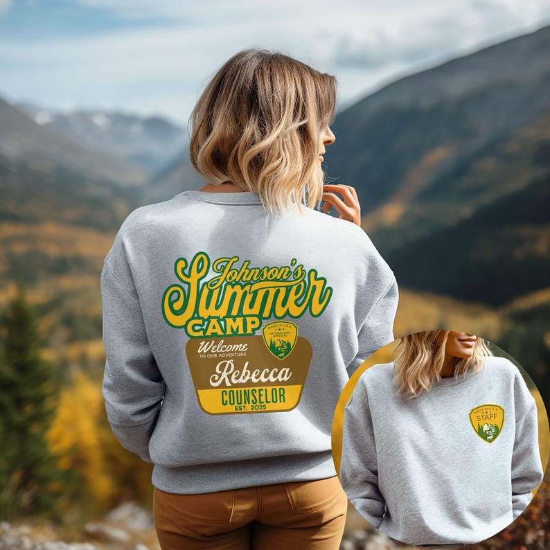 Puede incluir: Sudadera gris claro con el texto "Johnson's Summer Camp" en verde y amarillo. Debajo, una insignia marr&oacute;n y dorada dice "Welcome to our adventure" y "Rebecca Counselor Est. 2025". Una insignia m&aacute;s peque&ntilde;a est&aacute; en la parte delantera.