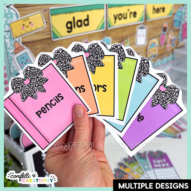 May include: A set of six colorful rectangular labels featuring a black and white patterned bow graphic at the top. Each label is a different color including pink, orange, yellow, green, light blue, and purple, with black text printed on each.