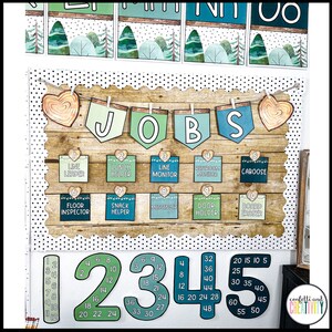 May include: A classroom notice board with a wooden background and a banner that reads "JOBS". The board is decorated with hearts, lights, and small squares with different job titles, such as "Line Leader", "Lunch Helper", and "Board Eraser". There are also large numbers from 1 to 48 on the board, with each number having a different colour.