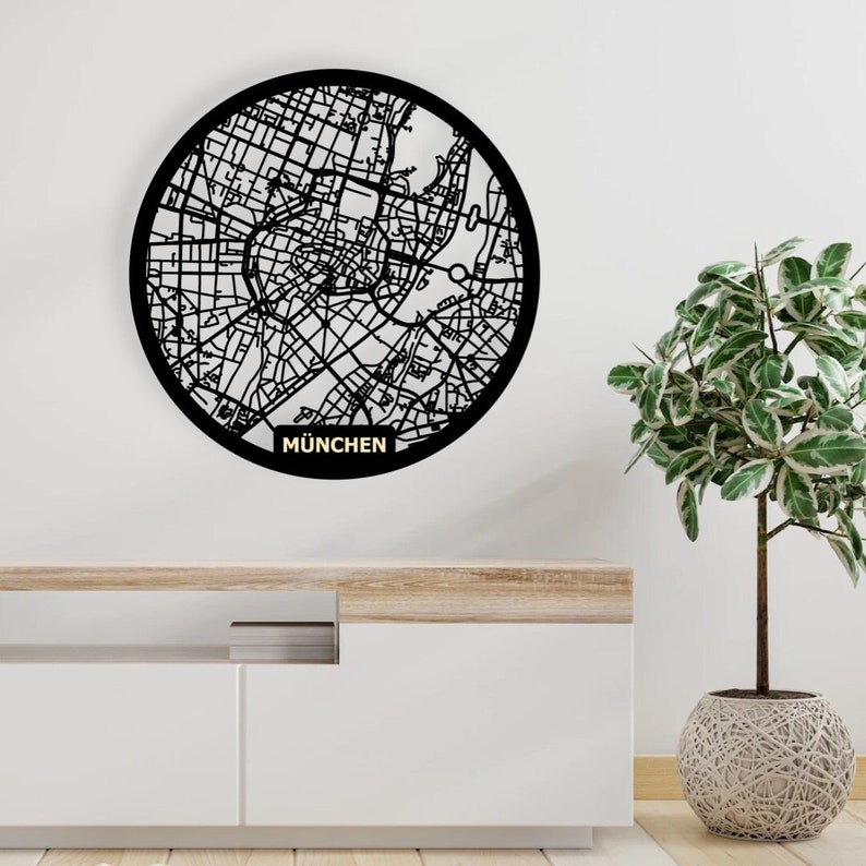 May include: Black and white circular wall art featuring a detailed map of Munich, Germany. The map is surrounded by a black circle and the word "MUNCHEN" is written in gold below the map.