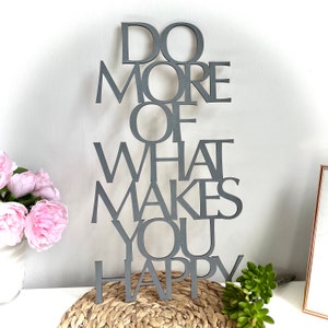 May include: Gray wooden sign with the text "Do More Of What Makes You Happy".