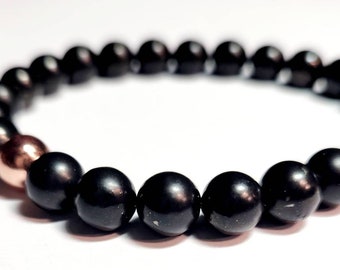 May include: A black beaded bracelet with a single rose gold bead.
