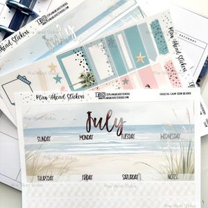 May include: A collection of planner stickers with a coastal theme. The stickers feature beach scenes, starfish, and the word "July" in a metallic font. The stickers are designed for use in a planner or journal.