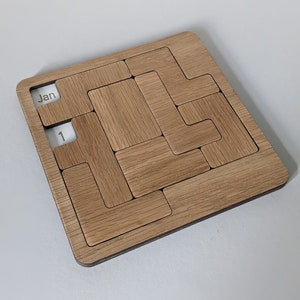May include: A wooden calendar with a sliding puzzle design. The calendar is set to 1st January.
