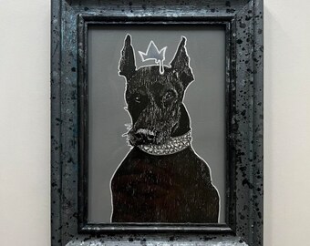 May include: A black and white illustration of a dog wearing a crown and a jeweled collar. The dog is framed in a black wood frame with a distressed finish.